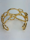 back view of gold-tone openwork cuff bracelet with abstract organic shape