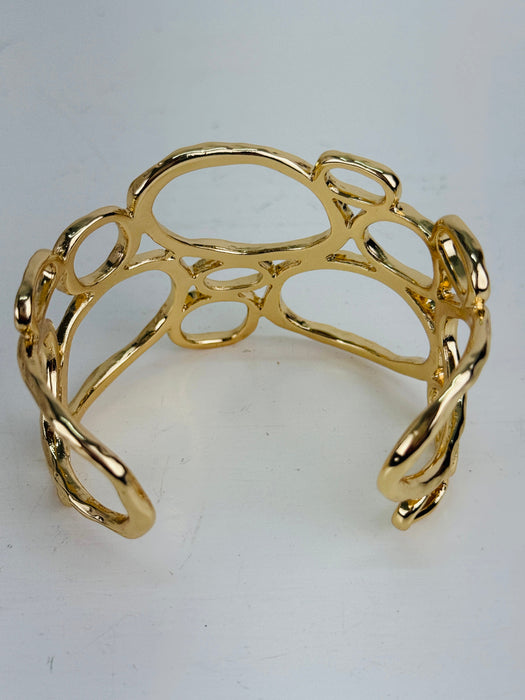 back view of gold-tone openwork cuff bracelet with abstract organic shape