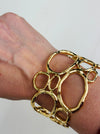 gold-tone openwork cuff bracelet with abstract organic shape displayed on a model