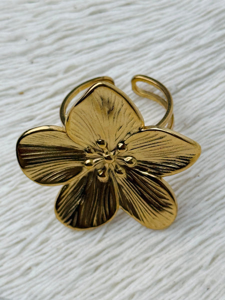 Adjustable silver-tone statement ring featuring a five-petal flower with textured detail, displayed on a white background.