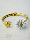 gold tone bangle bracelet with bee and white daisy enamel detail