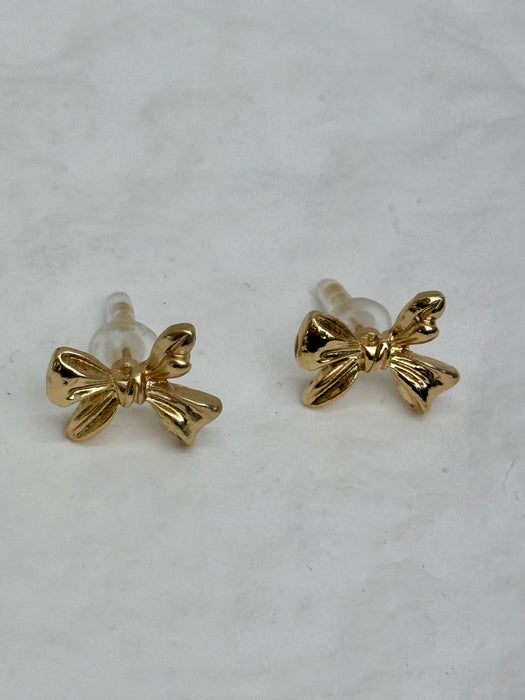 close-up of small gold bow earrings