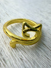 Gold cat-shaped ring on a textured white surface