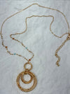 Gold necklace with circular pendants on a white background