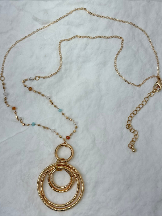 Gold necklace with circular pendants on a white background