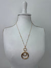 Gold necklace on a mannequin bust against a white background
