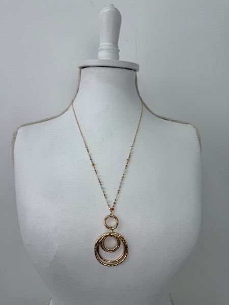 Gold necklace on a mannequin bust against a white background