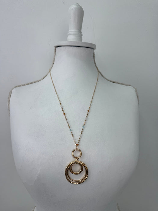Gold necklace on a mannequin bust against a white background