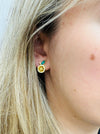 Close-up of a person wearing a gold citrus earring with green accents.