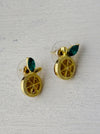 A pair of gold-colored citrus fruit stud earrings with green enamel and crystal leaves, displayed against a white background.