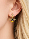 Gold bee-shaped earring worn by a person with blonde hair.