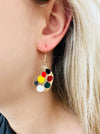 A pair of gold-colored earrings featuring a paint palette and paintbrush design.
