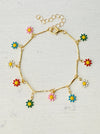 A gold tone bracelet with colorful enamel daisy charms, displayed against a white background.