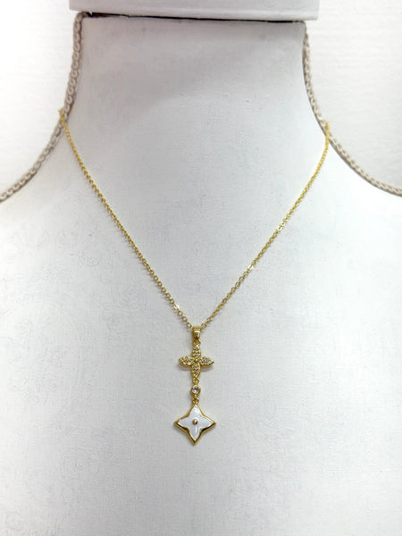 elegant gold necklace with crystal cross detail and enamel  on a mannequin bust.