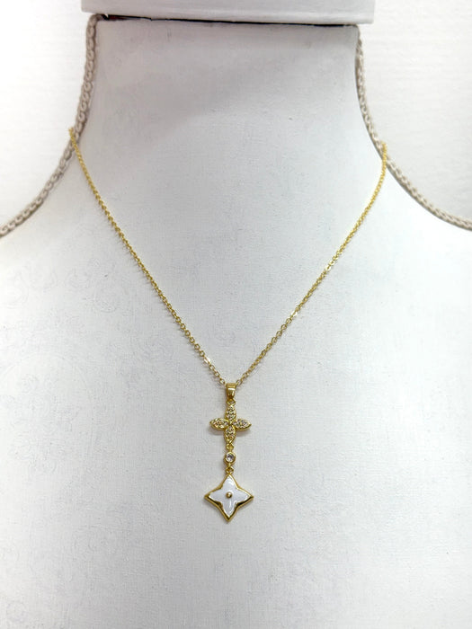 elegant gold necklace with crystal cross detail and enamel  on a mannequin bust.