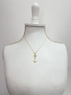 Gold necklace with a cross pendant on a mannequin bust against a white background