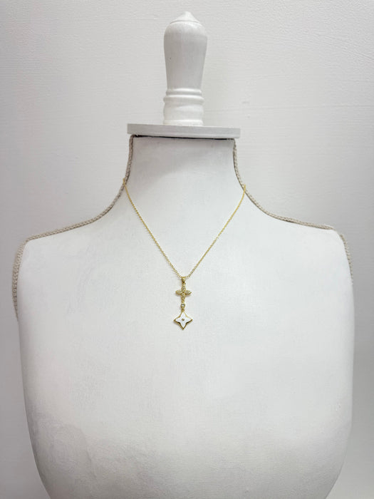 Gold necklace with a cross pendant on a mannequin bust against a white background