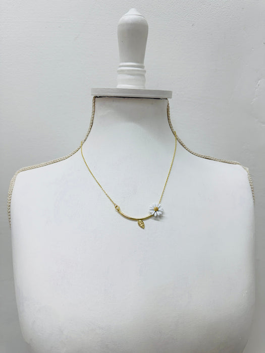 Gold necklace on a mannequin bust against a white background