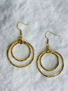 Gold hoop earrings on a textured white background