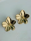 Gold flower-shaped earrings on a light gray background