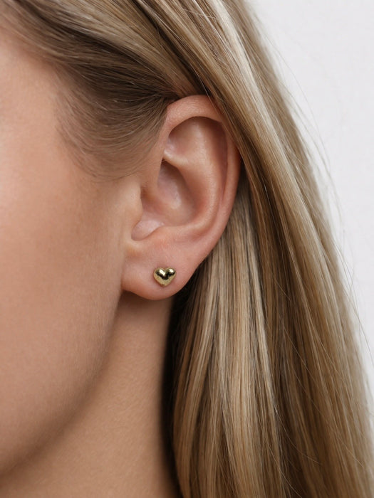 small gold heart stud earrings  on a model
