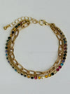Gold chain bracelet with multicolored gemstones on a white background