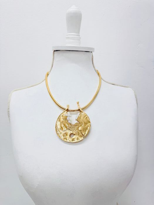 Modern gold tone necklace with organic textured pendant and natural pearl details.