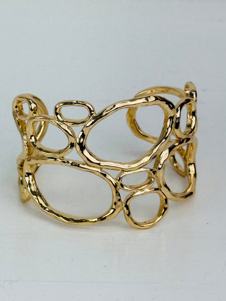 front view of gold-tone openwork cuff bracelet with abstract organic shape
