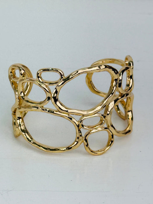 front view of gold-tone openwork cuff bracelet with abstract organic shape