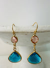 Elegant gold drop earrings with pink crystal and deep blue teardrop stone.