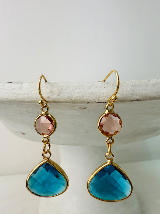 Elegant gold drop earrings with pink crystal and deep blue teardrop stone.