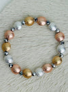 Tri-tone metallic beaded elastic bracelet in gold, silver and rose gold tones with grey spacer beads displayed on a white background.
