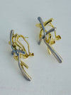 Gold and silver tone abstract earrings with interwoven curved bars.