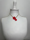 Red floral earring on a white bust against a gray background