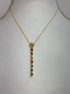 front of gold star necklace with multicolour gemstone drop pendant.
