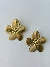 close-up of gold-tone textured flower stud earrings