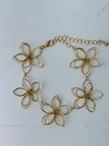 Delicate gold-tone floral bracelet with linked open-petal flower design and adjustable chain extender, displayed on a white background.