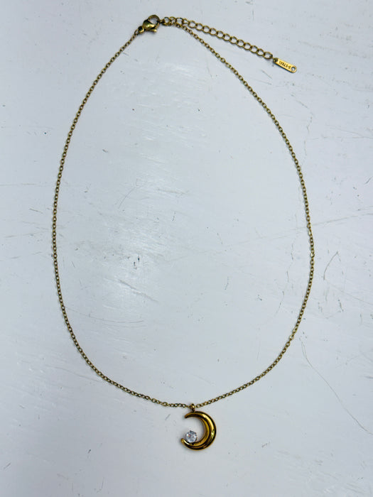 Gold necklace with a crescent moon pendant with crystal star detail on a white background