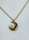 Gold crescent moon necklace with a diamond on a white background