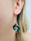 close -up of green enamel calla lily drop earring with pearl detail on a model