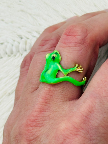 Green enamel frog adjustable ring with gold-tone details, displayed on a model.
