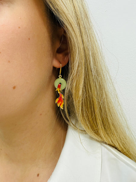 close-up of elegant earring with a jade style ring and Koi fish design.