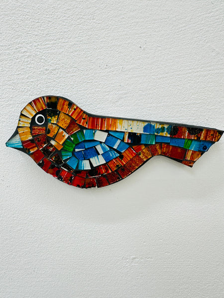 A colorful mosaic glass bird with gold accents, displayed against a white background