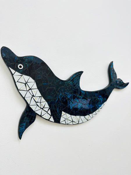 A handmade and hand-painted mosaic glass dolphin with sea blue, turquoise, and blues colours on mdf base