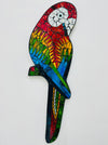 A colorful mosaic glass parrot with a geometric pattern, hand painted and designed to be hung by a hook.