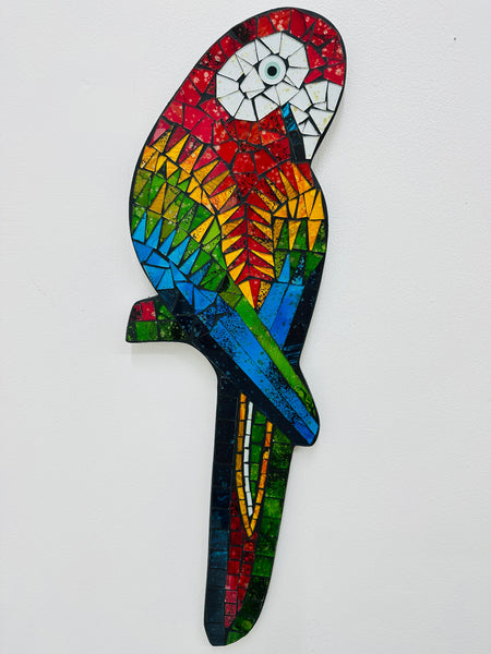 A colorful mosaic glass parrot with a geometric pattern, hand painted and designed to be hung by a hook.