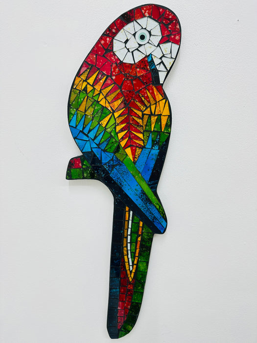 A colorful mosaic glass parrot with a geometric pattern, hand painted and designed to be hung by a hook.
