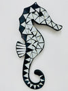 A handmade mosaic glass seahorse with a geometric pattern in white and blue on mdf base