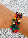 A colourful handmade wooden bracelet displayed on a model