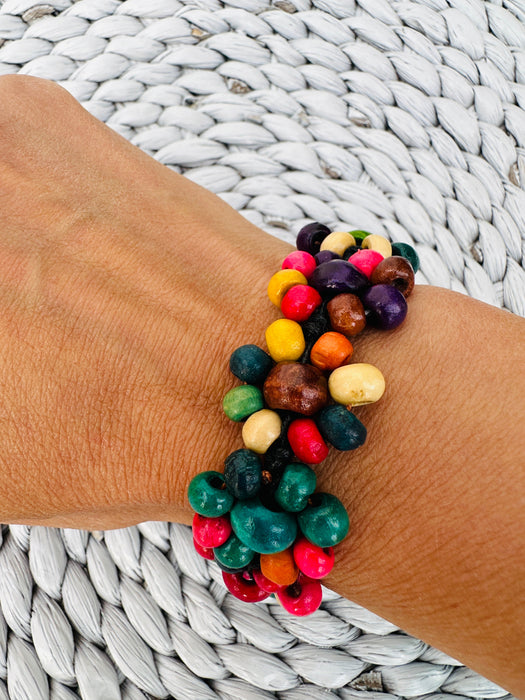 A colourful handmade wooden bracelet displayed on a model